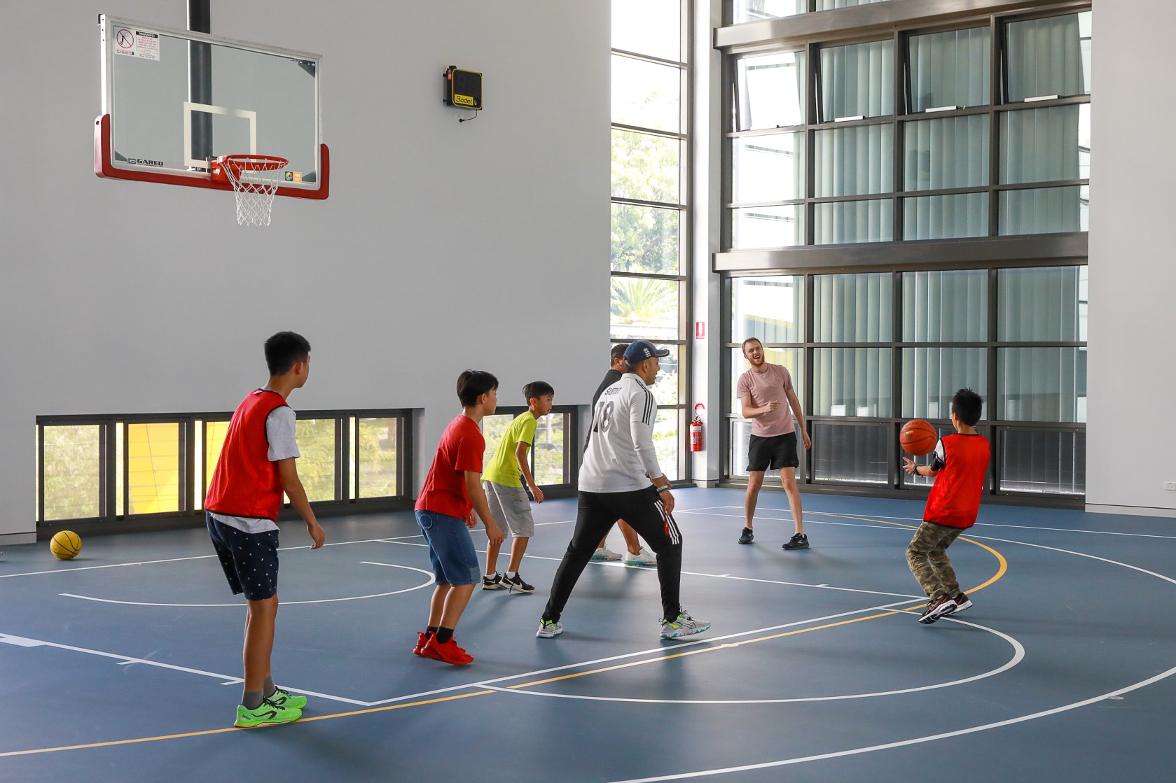 Kids playing basketball on an indoor court