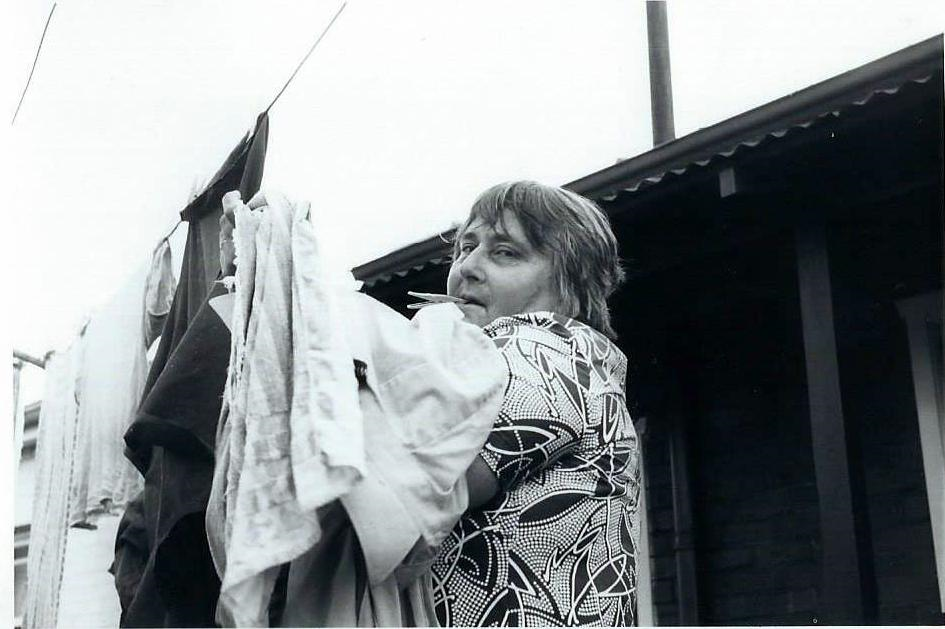 historical photo of woman hanging clothes on a line