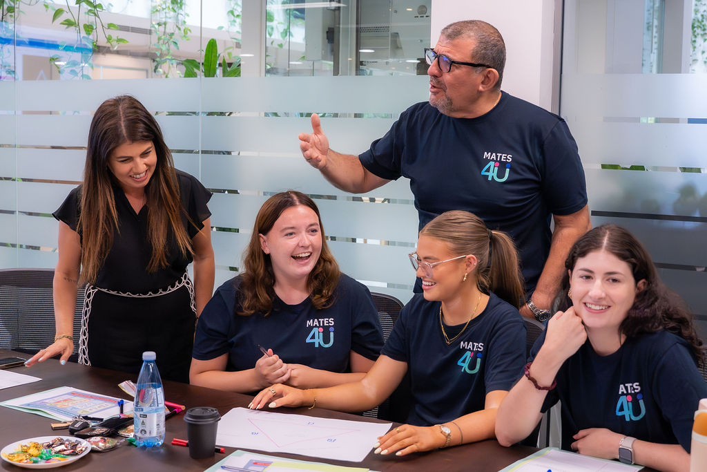 group of people laughing while sitting at desk